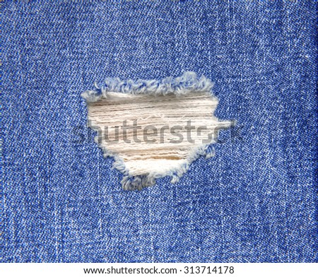 Blue denim jeans in bright color tear up surface condition present the old damaging fabric damaged detail of texture background
