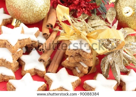 Christmas star-shaped cinnamon cookies with gold decorations. Tied up with a gold ribbon to give as a gift.