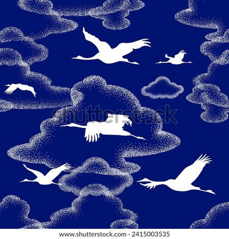 white silhouettes of flying cranes on the background of unusual clouds of dots. Seamless pattern, repeating background in two colors - blue and white