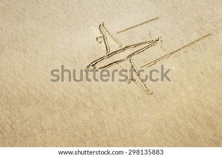 Drawing of an airplane in the sand on the beach.