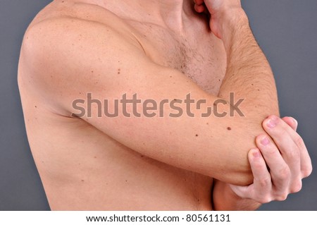 Young man with an expression of severe pain in his elbow