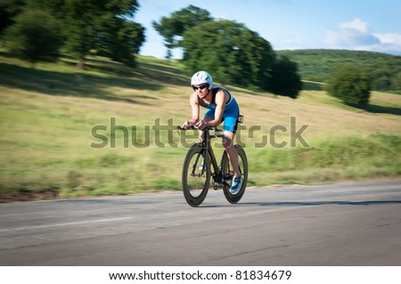 Panned shot of bicyclist in biking gear riding fast.