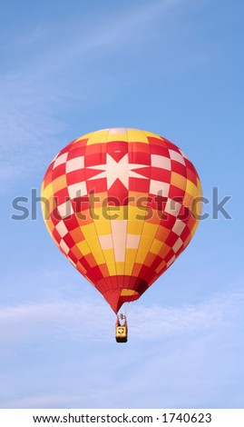 Warmly colored air balloon against cold blue sky