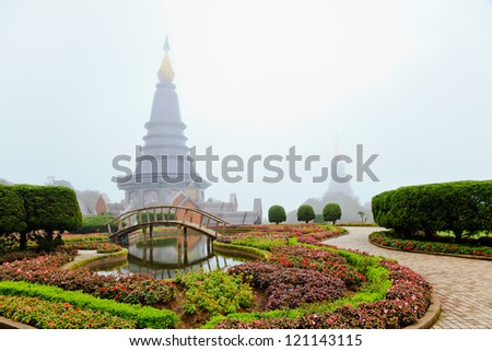 flower garden and the stupa in the morning mist, chiang mai, thailand
