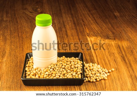 Soybean and a bottle of soybean milk on wooden table