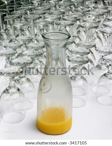 Line of crystal glasses on a caterers table with a carafe