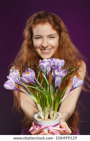 Happy female giving flowers crocuses. Shallow deep of field. Focus on flowers.