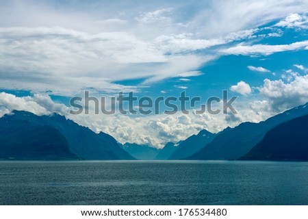 Norway. Fjord scene with hazy mountains and  cloudy sky in a overcast day