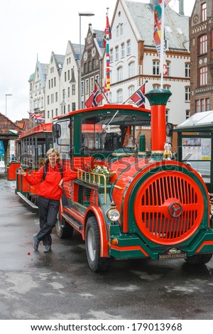 BERGEN, NORWAY - JULY 29, 2013: A road sightseeing train in Bergen, Norway. UNESCO World Heritage Site, Bryggen. Woman tourist showing thumb up.