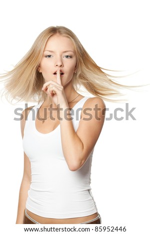 Young woman with finger on lips with hair lightly fluttering in the wind over white background