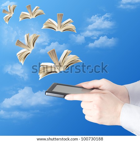Hand holding electronic book and opened books flying to the sky (education concept)