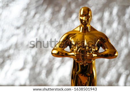 Hollywood Golden Oscar Academy award statue on silver background with copy space. Success and victory concept.
