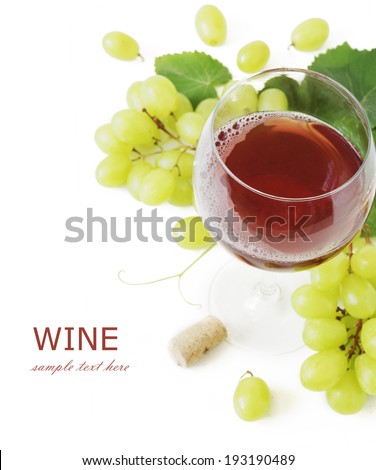 Red wine in glass, cork and grapes with leaves isolated on white background with sample text