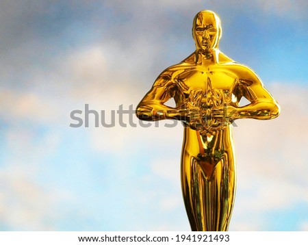 Hollywood Golden Oscar Academy award statue on sky background with copy space. Success and victory concept.