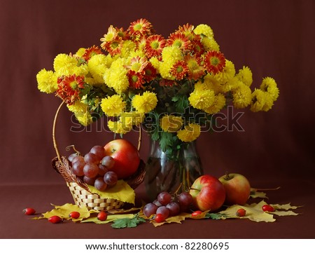 Still life with huge bunch of autumn flowers, grapes, red apples and hips