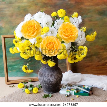 Still life with huge bunch of autumn flowers and roses, paints collection and wooden frame on painting background