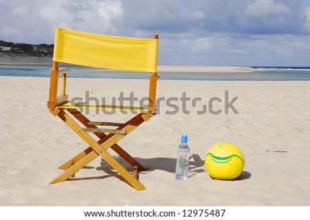 chair, water bottle, ball on the beach