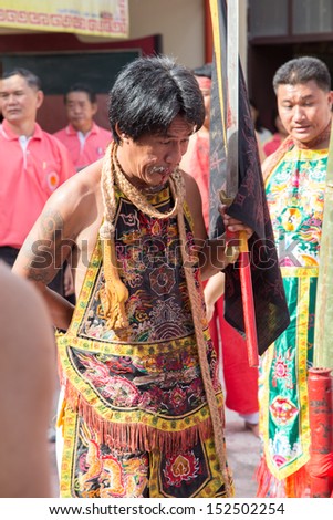 Yala, Thaland - July 18: Medium male is holding flag during offer sacrifice to Tabtim goddess ceremony on July 18, 2013 at Tabtim goddess shrine Aumphor Muang, Yala Province, Thailand.