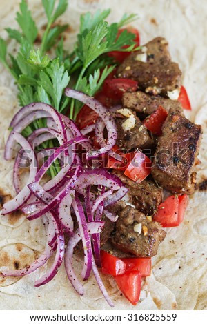 Grilled liver in flatbread with onion, tomato and parsley