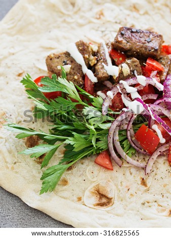 Grilled liver in flatbread with onion, tomato and parsley