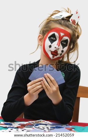 Young girl painted a colorful poker face playing cards game