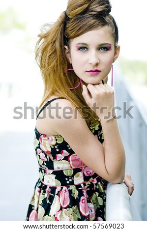 Closeup teenage girl model presenting clothes in the park near the water and a bridge