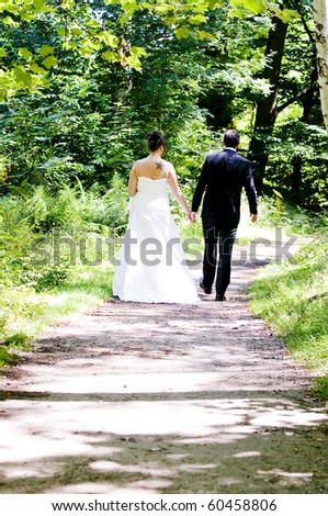 Bride and groom walking in the woods