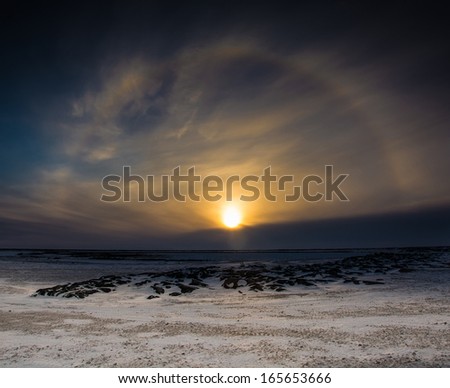 A sun dog around at sunset over the frozen, snow covered ground outside of Churchill, Manitoba
