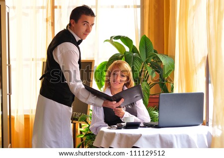 waiter giving menu to female costumer at the restaurant