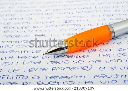 Orange ballpen on a letters background