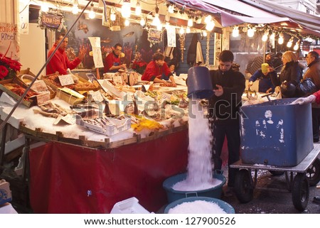 PALERMO - DECEMBER 22: men selling fish on the local market in Palermo, called Ballaro. This market is also tourist attraction in Palermo, Sicily, Italy on Dec. 22, 2012.