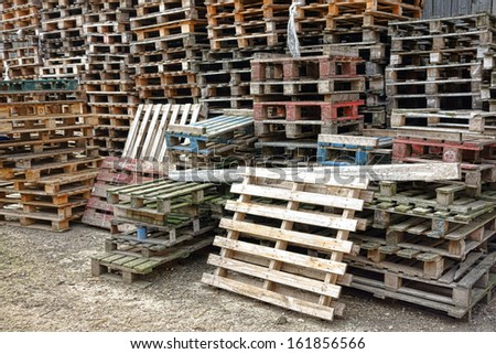 Shipping and transportation wood pallets in stacks waiting for bulk recycling in a freight warehouse shipment yard
