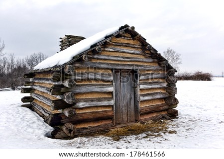 American Revolutionary War humble soldier shelter housing log wood cabin in winter snow at Valley Forge National Historical Park military camp of the Continental Army near Philadelphia in Pennsylvania