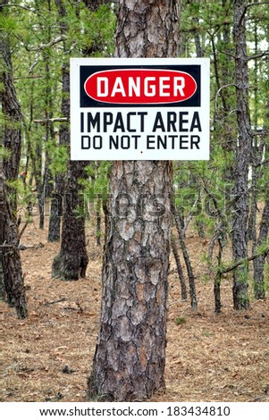 Danger impact area do not enter warning sign post at military shooting and firing training range to prevent unauthorized trespassing and safety entry prohibition of dangerous restricted area zone