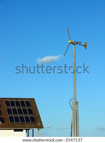 Wind turbine and solar panels on a roof as sustainable renewable energy sources