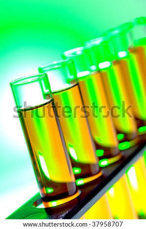 Laboratory glass test tubes filled with yellow liquid on a rack for an experiment in a science research lab