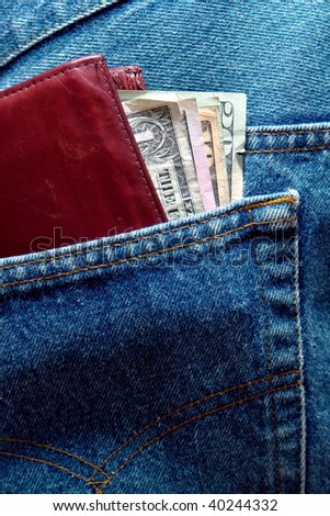 Assorted used US Dollar bills money in an old wallet in a blue jean denim pants back pocket