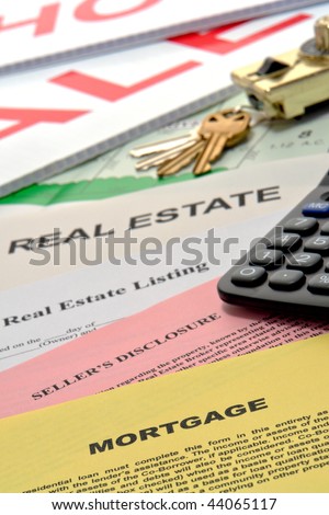 Real estate listing and home seller disclosure broker documents with financial lender mortgage paperwork on busy Realtor desk with keys and sale sign riders in realty agent office