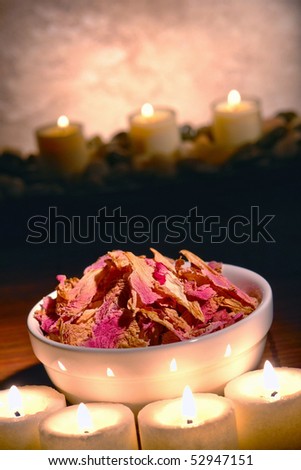 Dried flower petals in a bowl with candles in a spa