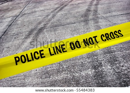 Street crime scene with police line do not cross yellow warning tape above road with tire tracks