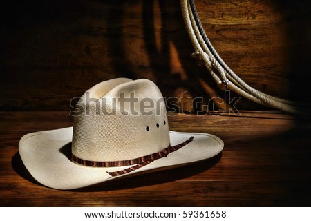 American West rodeo authentic cowboy white straw hat and lasso rope in a ranching wood barn
