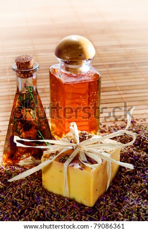 Natural artisan made aromatherapy scent bath soap bar and essential oil fragrance bottles with loose lavender seeds in a spa