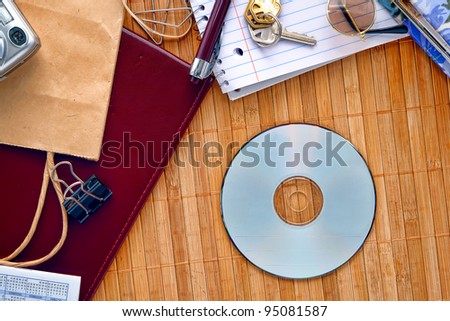 CD or DVD disc with empty blank copy space ready for text insert on a messy desk with everyday household stuff and things spread around