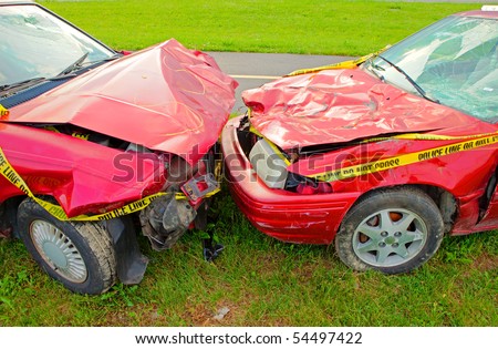 Head On Collision of Two Red Cars both with cracked windshields and smashed hoods.