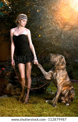 Happy elegant woman with big dog in autumn forest