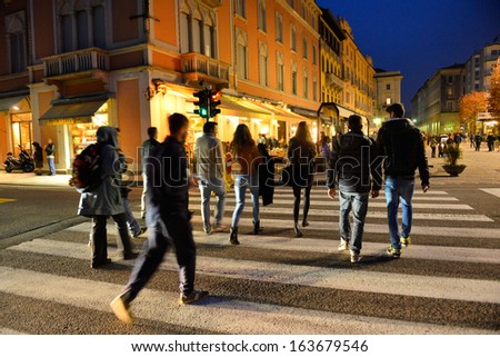 COMO, ITALY - NOVEMBER 16: Unidentified pedestrians at Como crossing crosswalk on November 16, 2013 in Como, Italy. The famous scramble crosswalk near the Como lake.