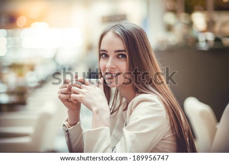 Beautiful smiling woman drinking coffee in cafe