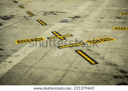A picture of black and yellow airport markings on concrete runway