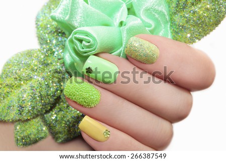 Manicure with green rose and a different design of sequins and rhinestones on nails.