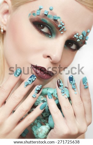 Manicure and makeup with beads and turquoise in the form of small stones and jewelry made of turquoise on the woman.